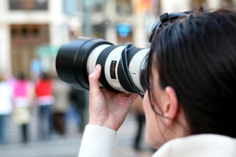 Journalists with a disability looking through a camera.